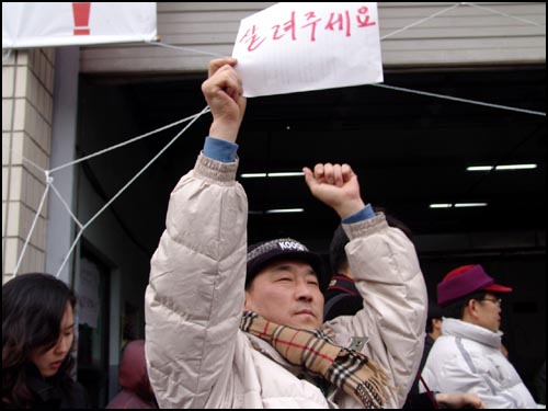 '살려주세요'라며 도움을 요청하고 있는 상인 